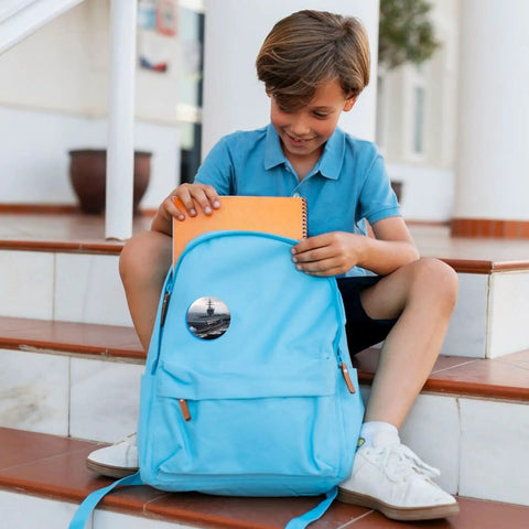 Boy with blue backpack featuring 12 Pack 2.4 Inch Round Button Pins Set Made From Durable Tinplate Metal With Custom Photo Prints