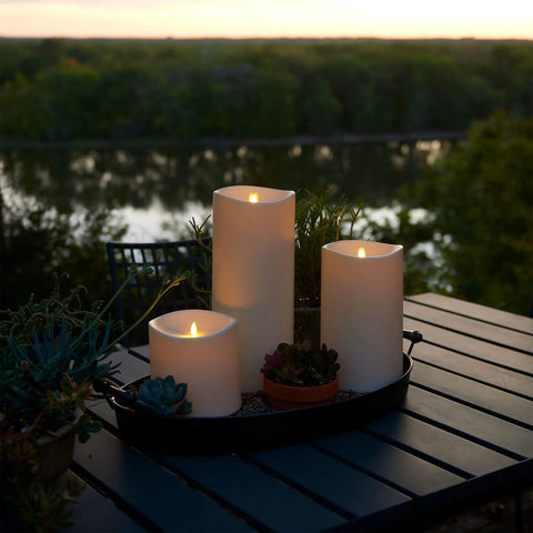 Outdoor Flameless LED Ivory Candle With Melted Edge, 3.75 x 7 Inches, Real Moving Flame, on patio table at sunset
