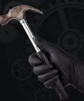 Black nitrile work gloves, medium, worn on hand gripping a claw hammer