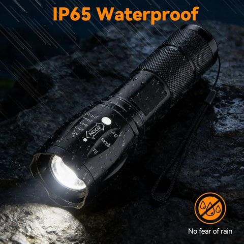 Beast Mode LED Flashlight Set, waterproof small tactical light on wet rock, showing zoomable lens, compact and rugged design.