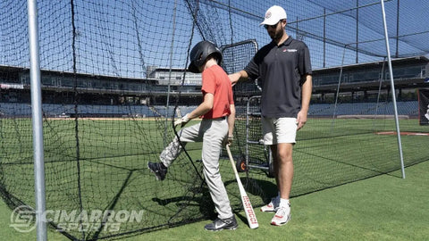 Fully Enclosed Baseball Softball Batting Cage Net With Easy Entry Door in use by player and coach on a sports field.