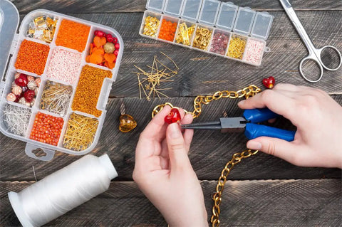 Person using pliers from 1500 Piece Silver Jump Ring Set With Lobster Clasps And Jewelry Pliers For DIY Jewelry Making Kit