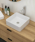 White Ceramic Square Vessel Bathroom Sink on wooden countertop with soap and towels, sleek contemporary design.