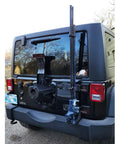 Rear view of Amazon Jack Handle Keeper mounted on Jeep tailgate; blue metal bracket for Hi-Lift and other jacks.