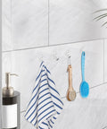Forty Pack Mini Clear Suction Cup Hooks With Sleek Metal Utility Rings holding a towel and brushes in bathroom.