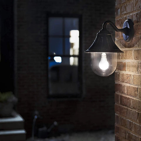 Orion Outdoor Solar Wall Light With 150 Lumen Warm White LED At 2700K on brick wall, glowing at night.