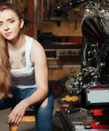 Person working in garage next to bike with Two Pack Stainless Steel Motorcycle License Plate Frames In Black Finish on floor.