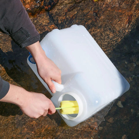 4 Gallon Camping Water Jug With Spigot For Emergency Water Storage Outdoors being cleaned in stream