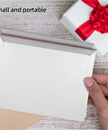 Hand holding Rigid Self Seal Mailers 100 Pack Cardboard Envelopes Keep Documents Flat Quick Self Seal Bags for mailing