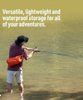 Person fishing in water with orange Lightweight 1.5L Dry Bag For Backpacking Kayaking And Travel Dope Durable PU Coated 70D Nylon With DWR Hypalon Roll Top Closure Multi Purpose Waterproof Storage Surf Blue on shoulder.