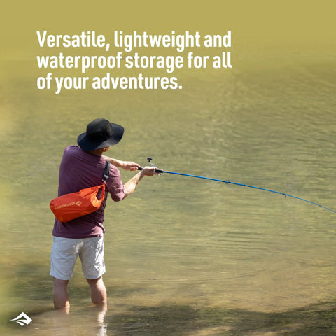Person fishing in water with orange Lightweight 1.5L Dry Bag For Backpacking Kayaking And Travel Dope Durable PU Coated 70D Nylon With DWR Hypalon Roll Top Closure Multi Purpose Waterproof Storage Surf Blue on shoulder.