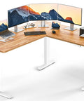 Ergear 63 Inch L Shaped Electric Standing Desk Adjustable Height Light Vintage Finish with multiple monitors and printer.
