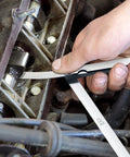 Hotop stainless steel 25-blade feeler gauge set with metric and imperial markings used to measure a gap in an engine.