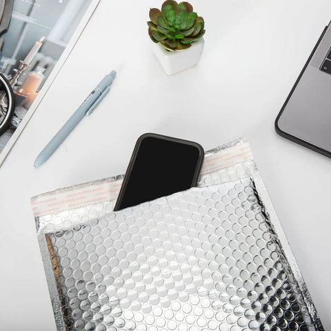 Phone entering 20 Pack Thermal Bubble Mailers, 8 By 11 Inches, Silver Metallic Self Seal Foil Mailing Envelopes on desk