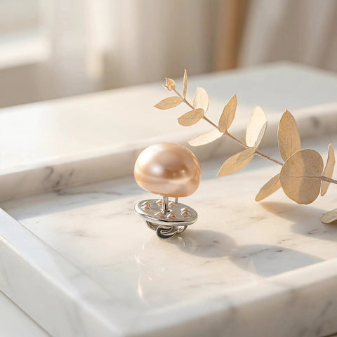 Close-up of a 25Pcs No Sew Faux Pearl Brooch Pin on a marble surface, showcasing its chic design and metal clip.