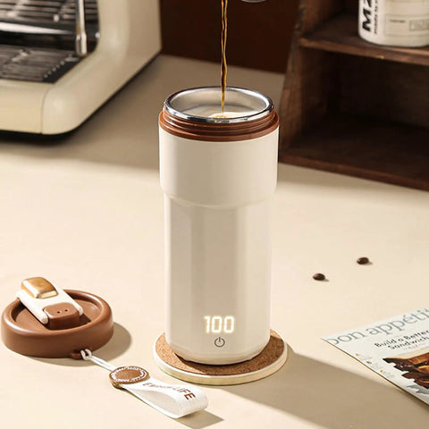 Self Heating Coffee Mug With Quick Temperature Display And Totally Spill Proof Lid on a table with coffee being poured.