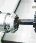 Lathe boring bar holder with carbide insert mounted in a spindle chuck — close-up view