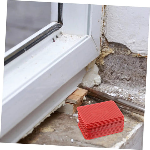 Red thickness composite shims used for leveling windows, part of 100 Pcs Plastic Door Frame Shims For Windows And Doors kit