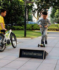 Children playing with Extra Wide Kids Jump Ramp For Skateboard, Scooter, Bike, BMX, RC Car And Dirt Bike 23.62 Inch Wide outdoors.