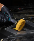 Gloved hand using rubber eraser wheel with 4 inch pad and adapter for car pinstripe removal adhesive and vinyl decal graphics