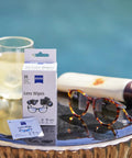 Front view of ZEISS Lens Wipes box for sunglasses cleaning (30 wipes) with a small sachet beside tortoiseshell sunglasses.