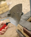 Person using Built Tough Masonry Tool Set for Pros and DIYers, 11 by 5.5 Inch Brick Trowel with concrete on wall
