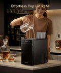 Woman refilling Crystal Clear Ice Ball Maker With CrystalFlux Technology For Countertop Use in home bar setting