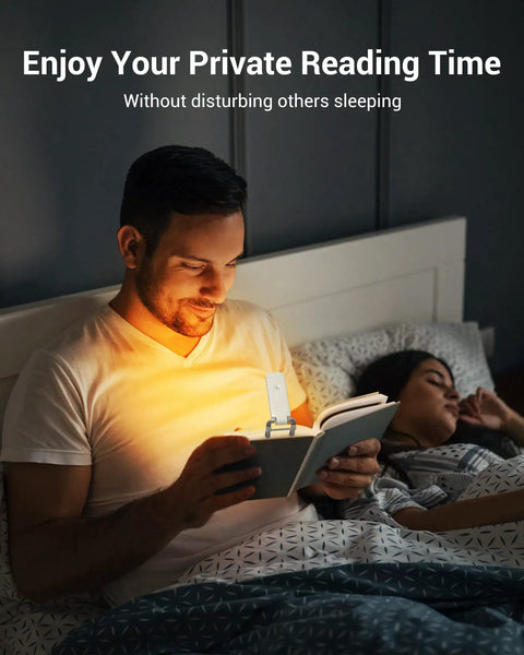 Man using Clip On Rechargeable Book Light For Late Night Reading With Amber And Warm White Glow while sitting in bed at night.