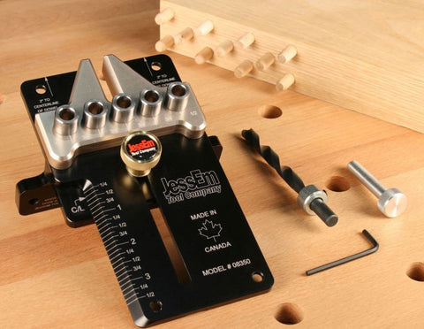 Super Handy Adjustable Doweling Jig For Spot On Three Eighth Inch Dowel Holes In Wood Projects Features One Eighth Increments Up To Three And Half Inches From Edge Durable Aluminum Build With Five Bushings Drill Bit Stop Collar Pin Included on a wood surface with dowels and tools