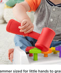 Child using red hammer on Toddler Tap And Turn Tool Bench Play Set For Tiny Tot Builders with colorful shape pegs, Fisher-Price