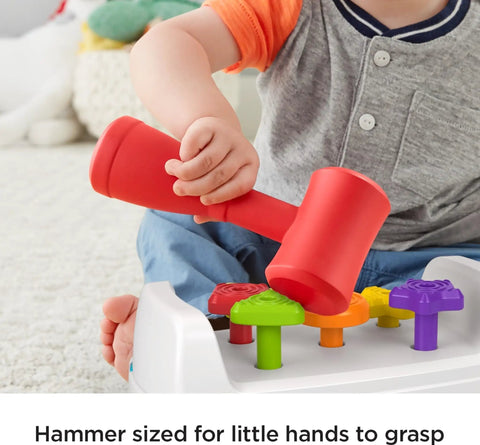 Child using red hammer on Toddler Tap And Turn Tool Bench Play Set For Tiny Tot Builders with colorful shape pegs, Fisher-Price