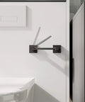 Matte Black Double Post Pivoting Toilet Paper Holder Wall Mount Modern Square Roll Holder in a compact bathroom setting.