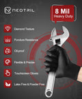 Front view of NEOTRIL black nitrile gloves (8 mil) worn on a hand gripping a wrench.