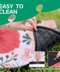 Close-up of waterproof extra large picnic blanket showing floral pattern and scratch-proof backing while being folded outdoors.