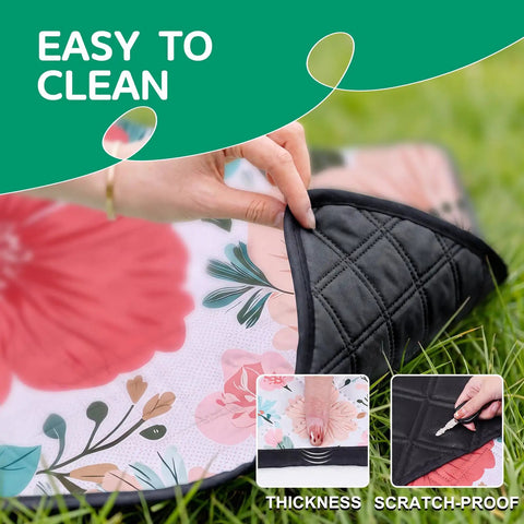 Close-up of waterproof extra large picnic blanket showing floral pattern and scratch-proof backing while being folded outdoors.