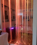 16W RGBW Fiber Curtain Lights Kit For Waterfall Backdrop in a sensory room, glowing in orange hues, with 450 strands of fiber optic cables.
