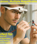 Close-up of person using Lighted Magnifier Headset With Five Interchangeable Lenses for detailed model painting.