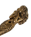 Close-up of antique aqua mermaid shaped metal wall hook from set of 2, part of beachy coastal decor, showing detailed craftsmanship.