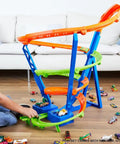 Child playing with Spiral Speed Crash Track Set With Motorized Booster, 29 Inch Tall Track, Includes One To Sixty Four Scale Car