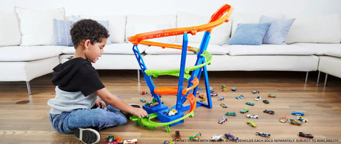 Child playing with Spiral Speed Crash Track Set With Motorized Booster, 29 Inch Tall Track, Includes One To Sixty Four Scale Car
