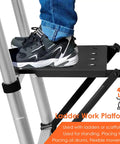 Pro Grade Heavy Duty Ladder Platform With 400 Lb Capacity Anti Slip Standing Surface And Tool Tray Rock Solid Safety Locking Wobble Free Extension Ladder Stand For Painting And Home Repairs Thick Steel Construction Black platform in use with person standing on ladder.