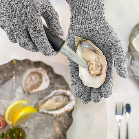 4 Pack Cut Resistant Gloves Level 5 Protection For Kitchen Prep And Food Handling, Anti Cut Safety For Meat Cutting, Wood Carving, Mandolin Slicing And More, Sizes Medium And Large being used for oyster shucking.
