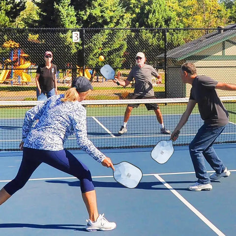 Players using Lightweight Fiberglass Pickleball Paddles Set Of 2 With Honeycomb Core And Grippy Handle For Superior Spin And Control in a match.