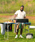 Man using Hanging Organizer For Outdoor FlexRail Camp And Cook Table, durable weather resistant pocketed storage, outdoor cooking