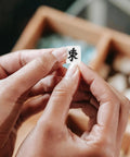 Hands holding a polymer mahjong bead with Chinese character, part of 100 Pcs Mahjong Beads For Jewelry Making With Pre Drilled Holes Charms Miniature Tile Spacers For DIY Earrings Bracelets And Necklaces Polymer Clay Chinese Tile Beads 0.39 Inch First Win Bead Crafting Gift Idea.