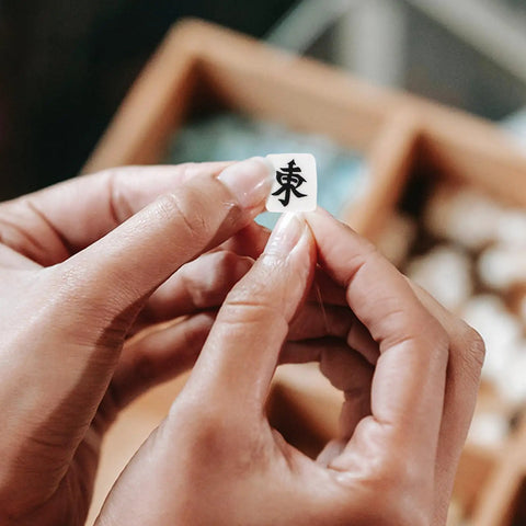 Hands holding a polymer mahjong bead with Chinese character, part of 100 Pcs Mahjong Beads For Jewelry Making With Pre Drilled Holes Charms Miniature Tile Spacers For DIY Earrings Bracelets And Necklaces Polymer Clay Chinese Tile Beads 0.39 Inch First Win Bead Crafting Gift Idea.