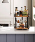 Smooth Spin Two Tier Lazy Susan Spice Rack Organizer With Adjustable Height For Kitchen Counter And Cabinet Storage Rustic Brown Finish with spices and jars.