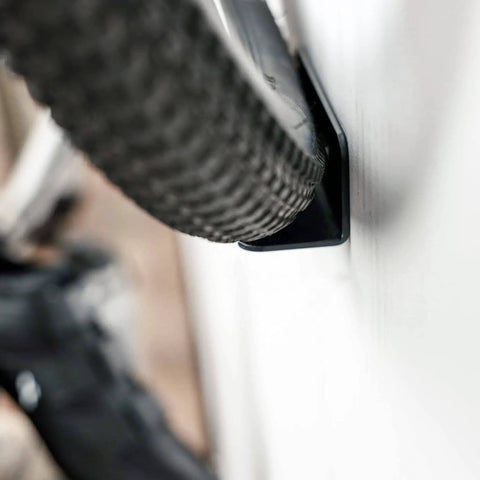 Close-up of a bike tire secured in a Wall Mounted Bike Pedal Hook Rack For Indoor Storage And Garage Organization With Tire Brackets Space Saving Hanger To Hold Three Bikes At A 45 Degree Angle No Handlebar Turning.