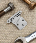 Heavy Duty Self Closing Cabinet Hinges For Kitchen And Bathroom Furniture in iron, shown with tools on fabric surface.