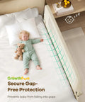 Toddler sleeping safely beside a Foldable Toddler Bed Rail 59 Inch Reinforced Carbon Steel Frame With Connectors, cream color.